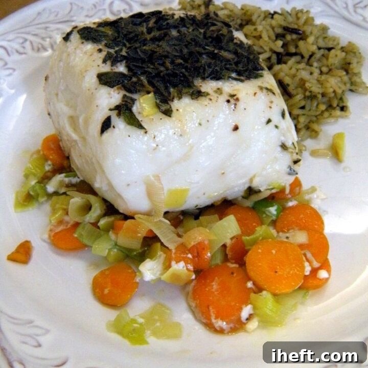 A piece of cooked Halibut over leeks and carrots, beautifully plated. 