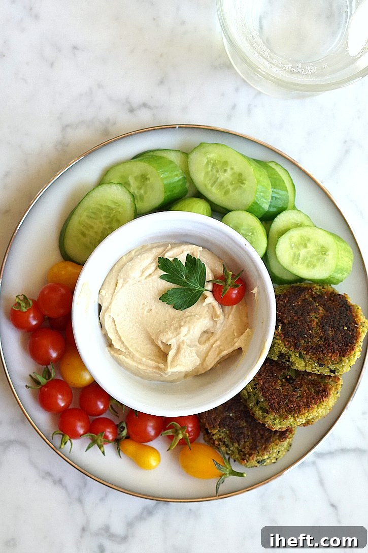 Vegan falafel served with cucumber, tomatoes, and hummus. 