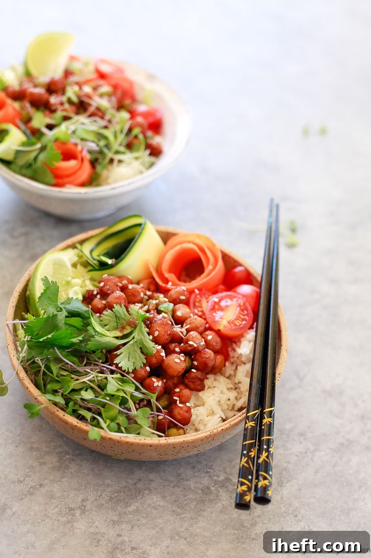 A stunning close-up of a finished Korean BBQ Chickpea Bento Bowl, showcasing the delightful blend of BBQ chickpeas, sesame seeds, delicate zucchini and carrot ribbons, microgreens, and fresh cilantro. A perfect plant-based Buddha bowl for any meal.
