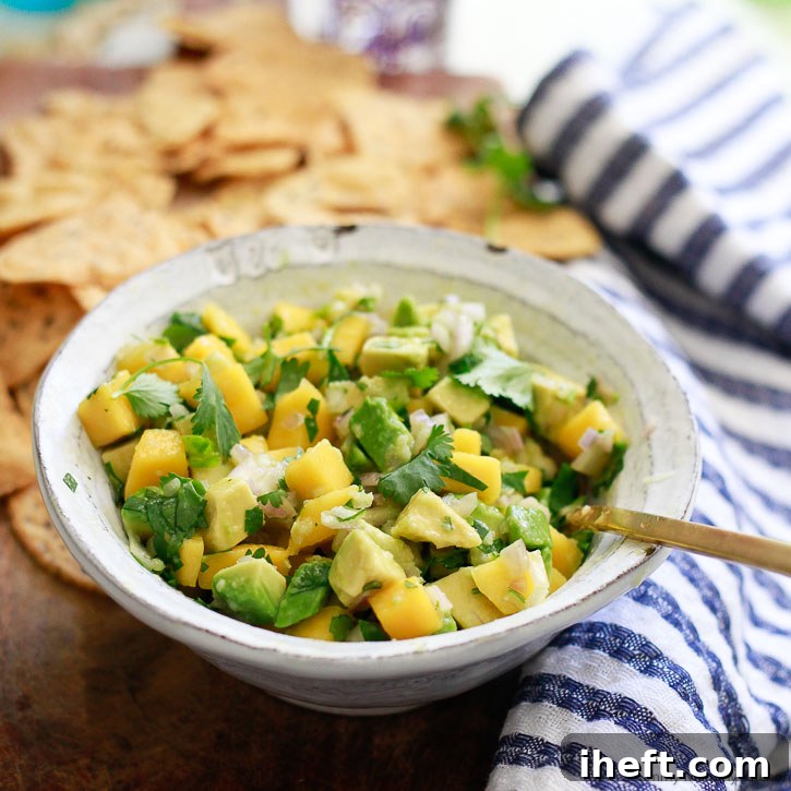 A close-up shot of a single serving bowl of mango avocado salsa, perfectly diced and mixed, showcasing its fresh and appealing texture, ready to be enjoyed.