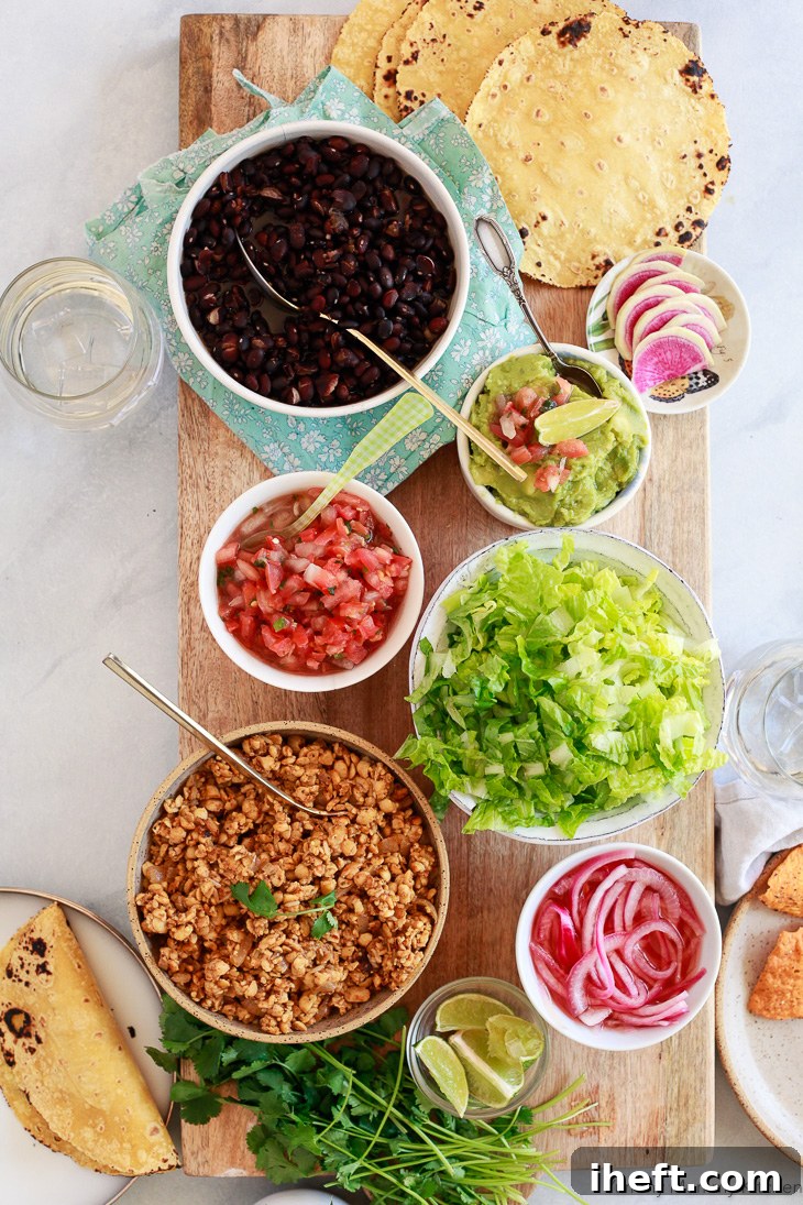 A vibrant vegan tempeh taco bar featuring soft tortillas, black beans, fresh salsa, crisp lettuce, and tangy pickled onions. Tempeh tacos are perfect for a wholesome vegan taco dinner.