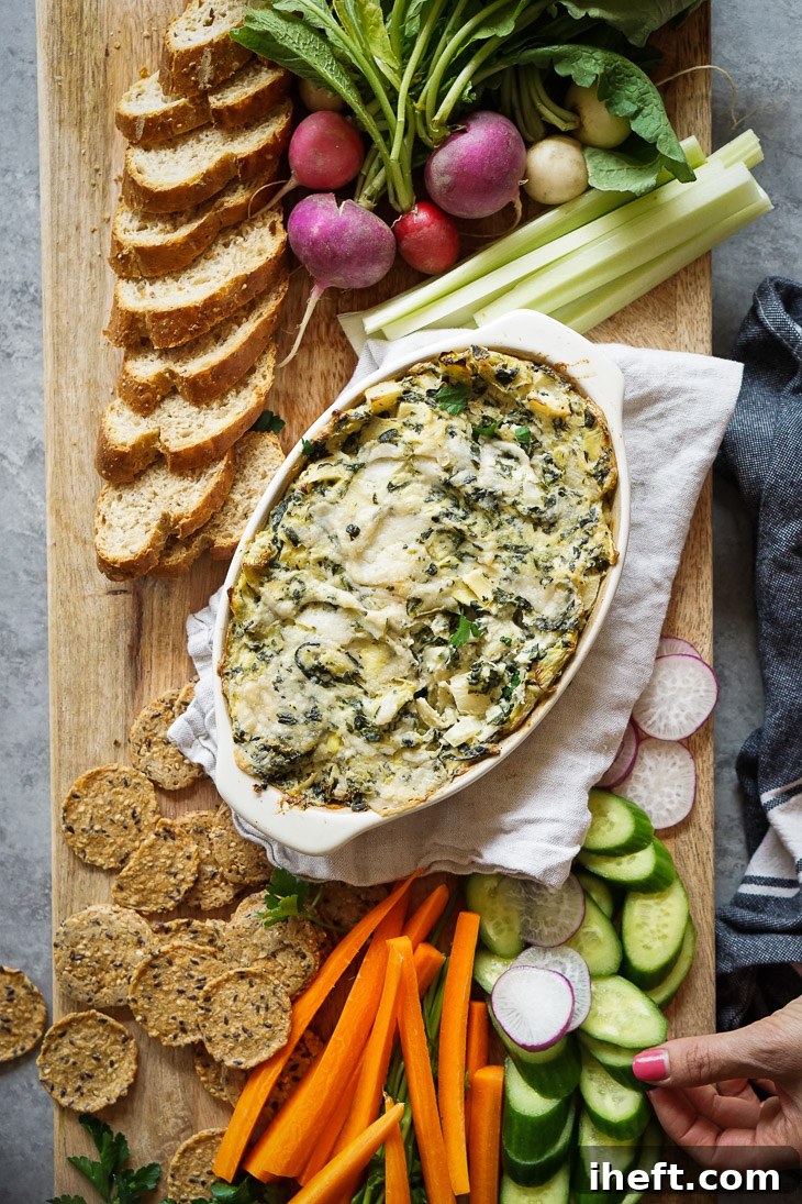 The best warm vegan spinach artichoke dip served with crudite vegetables, crackers, and baguette. This easy spinach artichoke dip made with cashew cream is an absolutely delicious and easy vegan appetizer. 