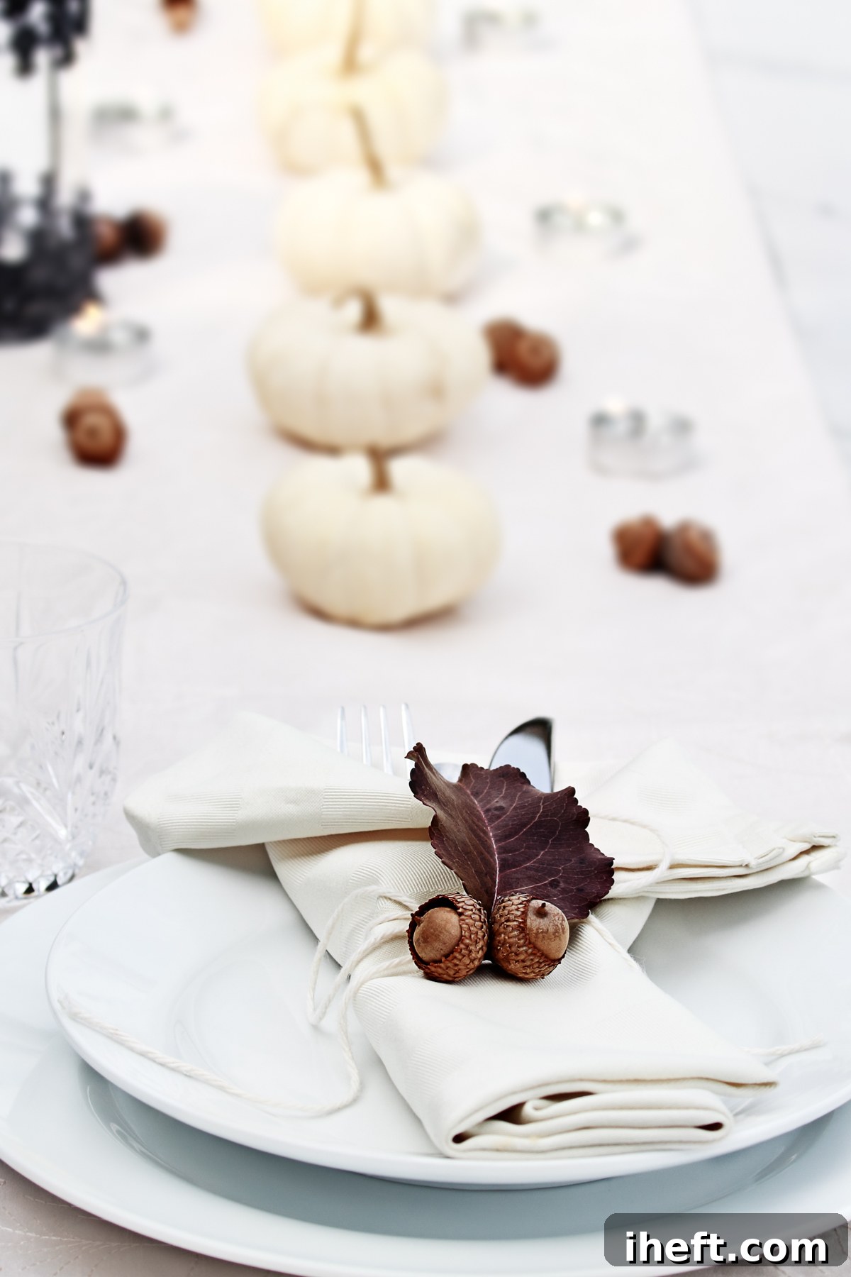 A beautifully minimalist Thanksgiving table set with an array of white pumpkins and various natural elements, creating a serene and elegant ambiance perfect for an autumn meal.