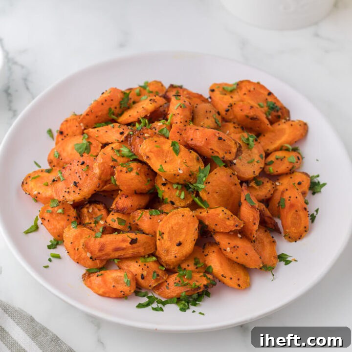 A white plate filled with air fryer sliced carrots garnished with parsley.