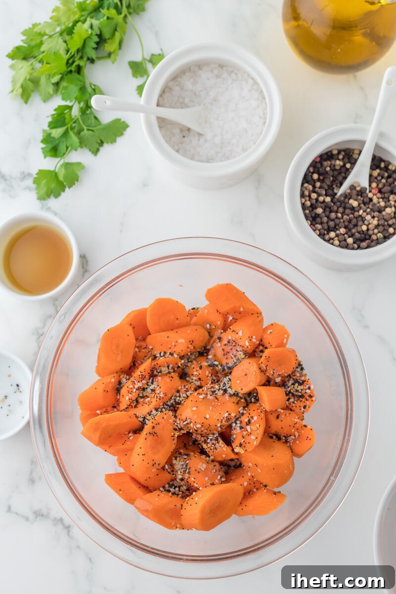 Carrot slices with seasonings in a glass bowl.