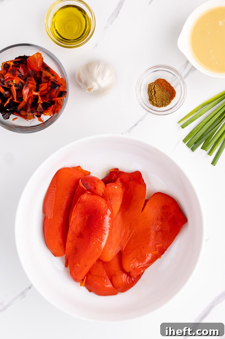 Roasted red bell peppers in a bowl with skins removed and discarded.