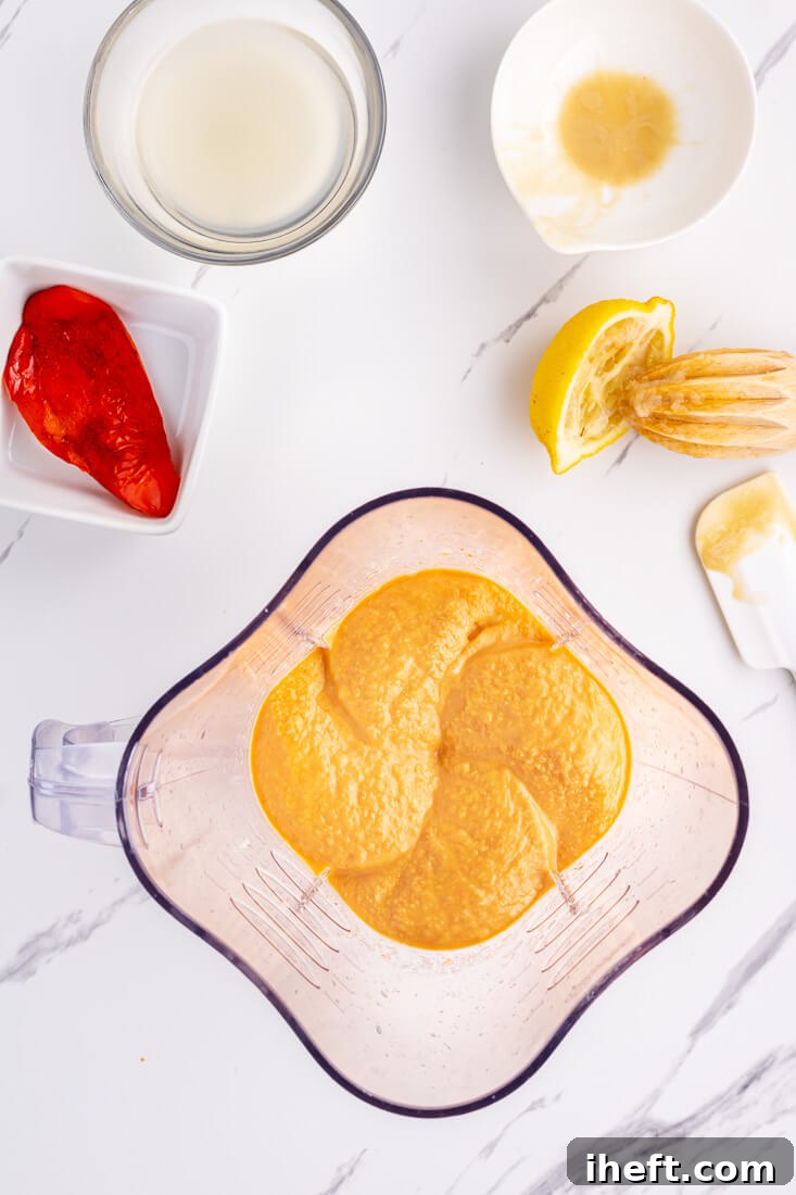 Homemade roasted red pepper hummus seen in a blender from above.