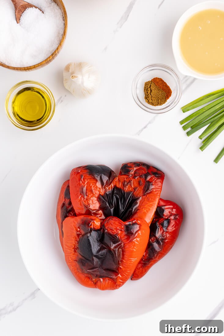 Roasted red bell peppers with charred skin in a white bowl.