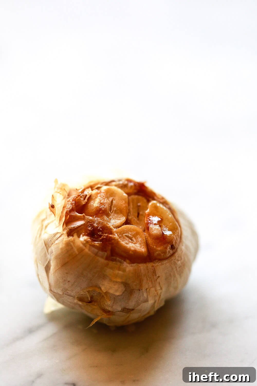 A head of roasted garlic with caramelized garlic cloves.