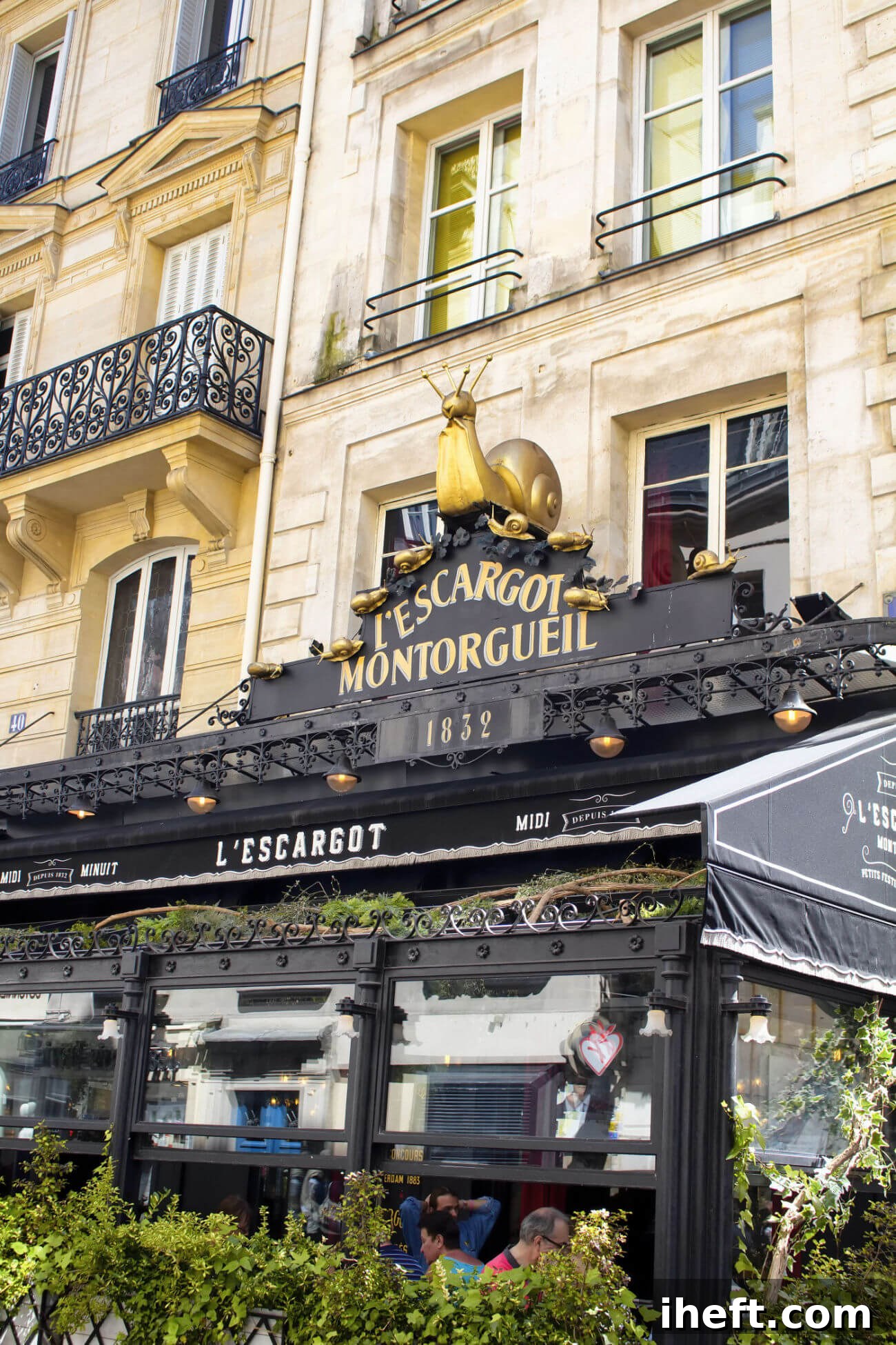 The iconic entrance of L'Escargot Montorgueil in Paris, France, featuring a golden snail atop its classic French restaurant sign, inviting diners to a historic culinary experience.