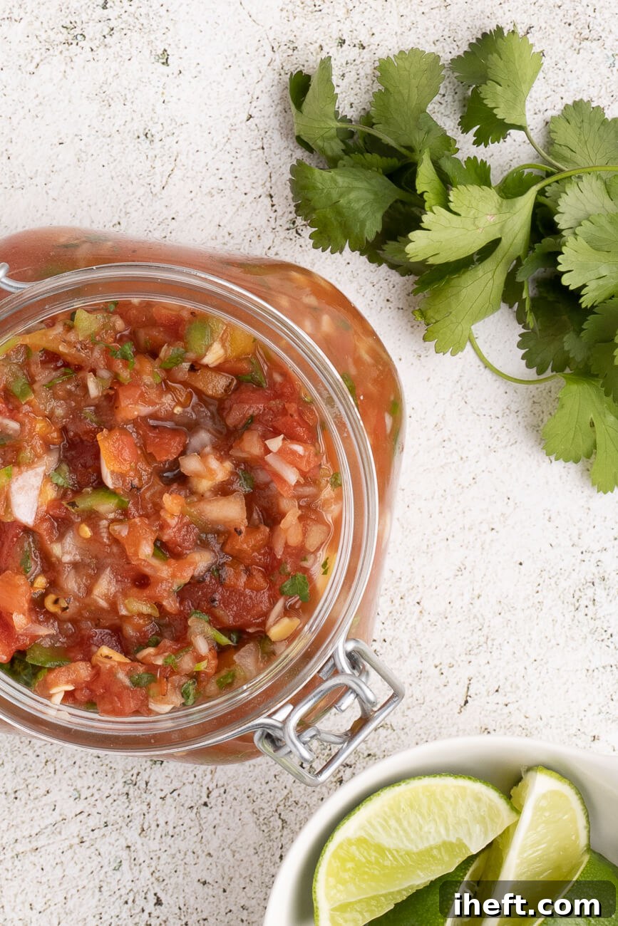 Chunky homemade salsa in a canning jar with an opened hinge lid.