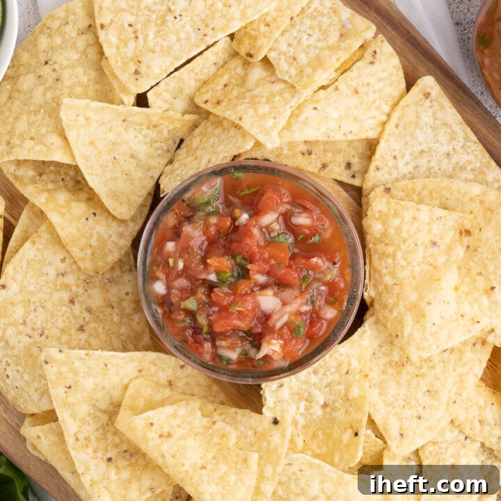 A bowl of chunky homemade salsa made with canned tomatoes served with chips.