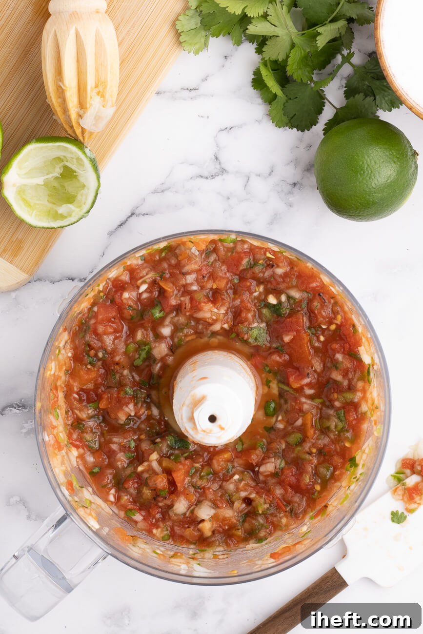 Chunky homemade restaurant style red salsa in a food processor.