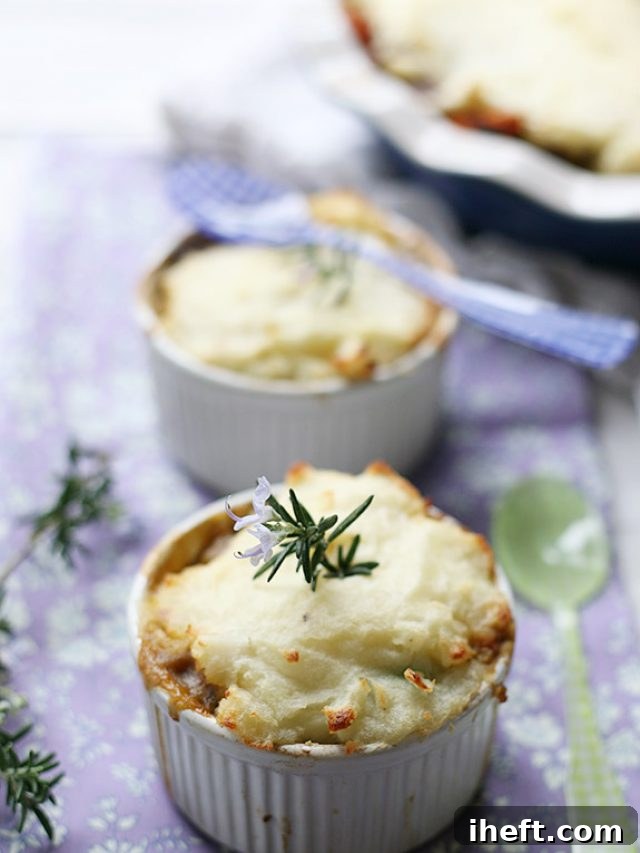 Two pristine white ramekins generously filled with a steaming, vegetarian Shepherd's Pie, showcasing its golden-brown mashed potato topping and rich filling. 