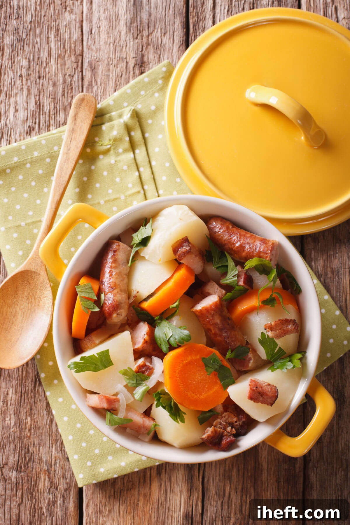 A vibrant yellow Dutch oven brimming with Irish Coddle, a traditional and comforting stew generously made with plump sausages, tender carrots, and hearty potatoes, creating a rustic and inviting meal. 