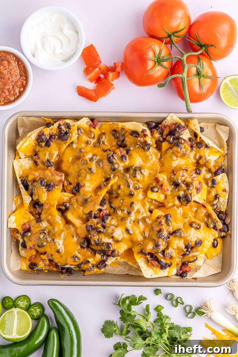 Sheet pan nachos with black beans and melted cheese.