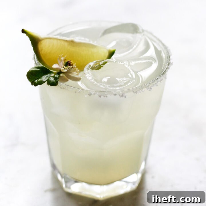 A Cadillac margarita on the rocks with salt rim and lime garnish.