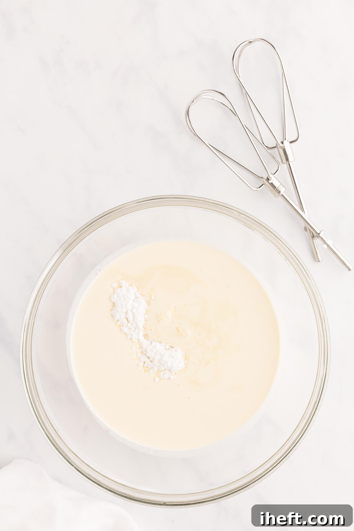 Whipping cream and sugar in a bowl.