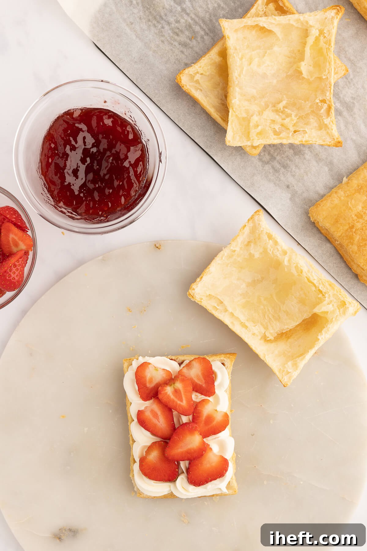 A strawberry Napoleon is made made by topping puff pastry with cream and fresh strawberries.