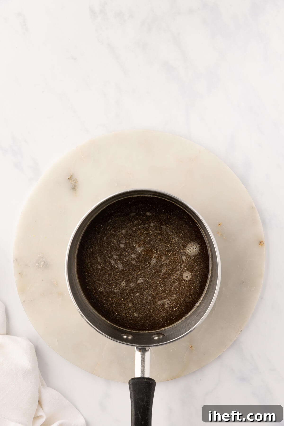 Brown sugar syrup is simmered in a small saucepan.