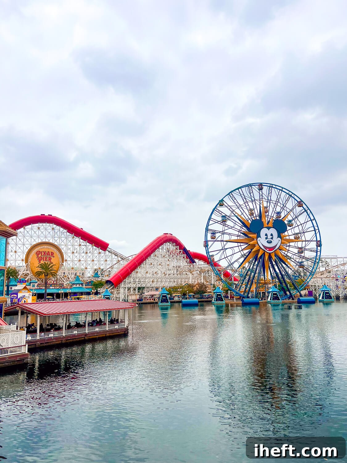A view of Disney California Adventure from Pixar Pier, that shows a large Mickey Mouse ferris wheel and roller coaster, the Incredicoaster. 