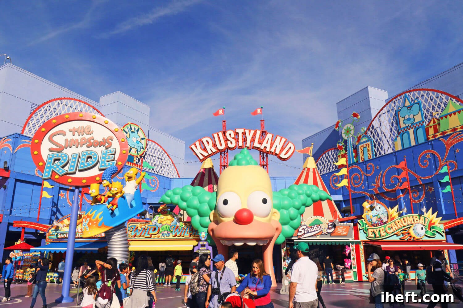 The vibrant, cartoonish landscape of The Simpsons Krustyland at Universal Studios Hollywood, featuring Krusty the Clown and signage for "Krustyland" and "The Simpsons Ride."
