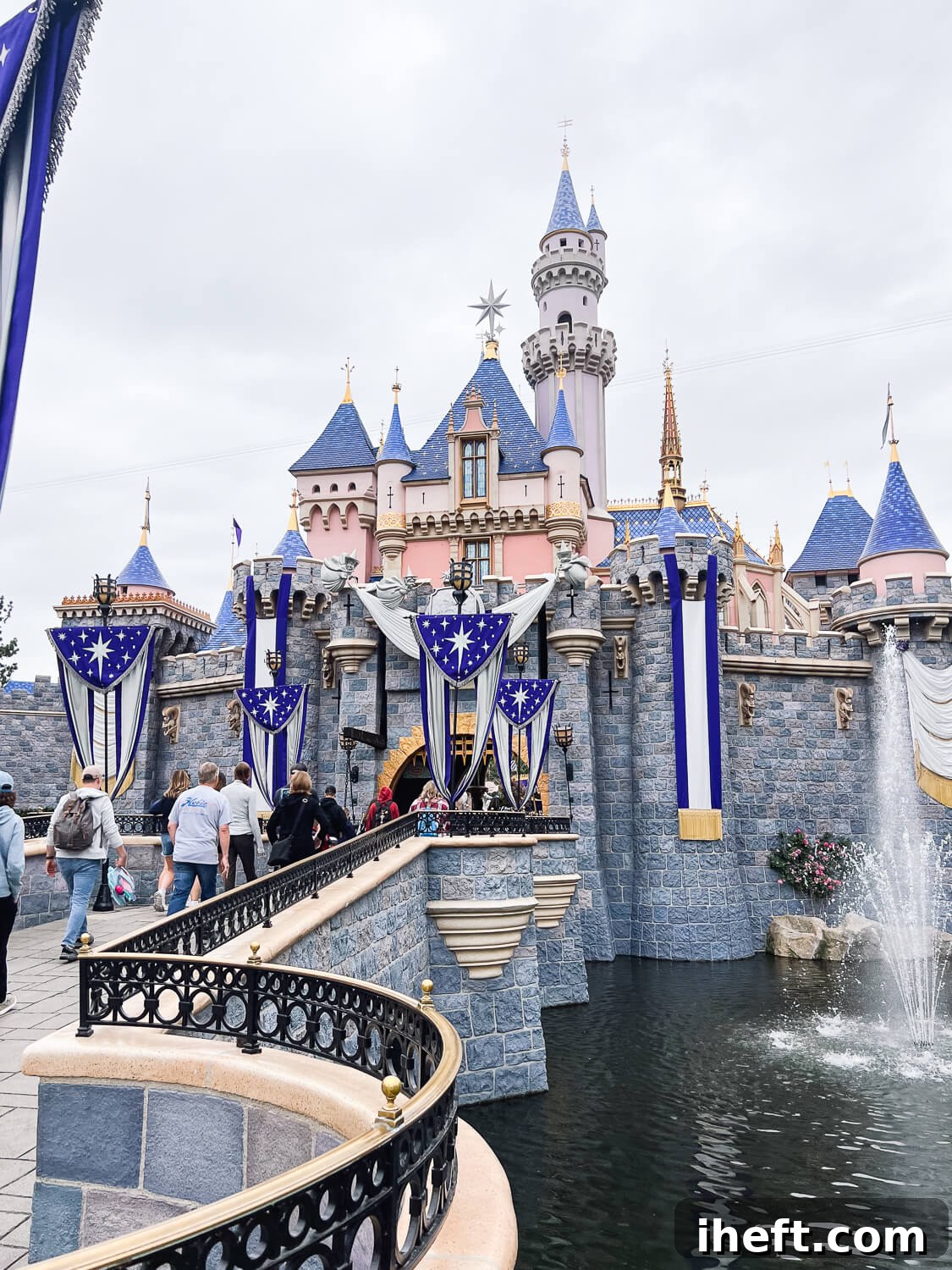 The enchanting Sleeping Beauty Castle walkthrough at Disneyland California, beautifully adorned in blue and silver for the 100th-anniversary celebration, evoking true fairytale magic.