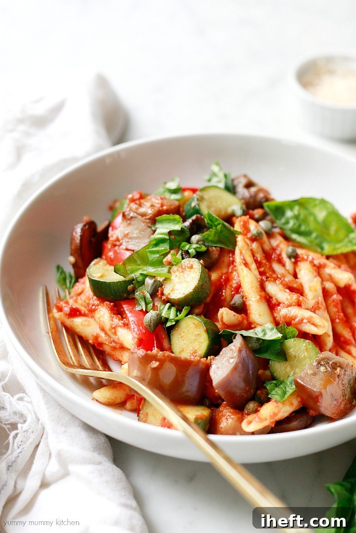 Delicious one-pot pasta with chunky marinara sauce, sautéed summer vegetables, fresh basil, and briny capers, presenting an easy vegetarian dinner solution.