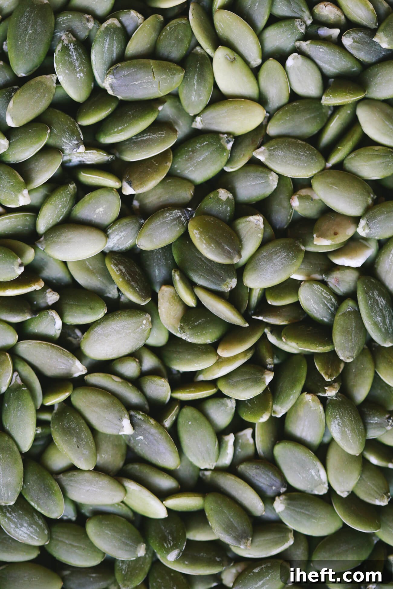 A close-up photo of green raw pepitas.