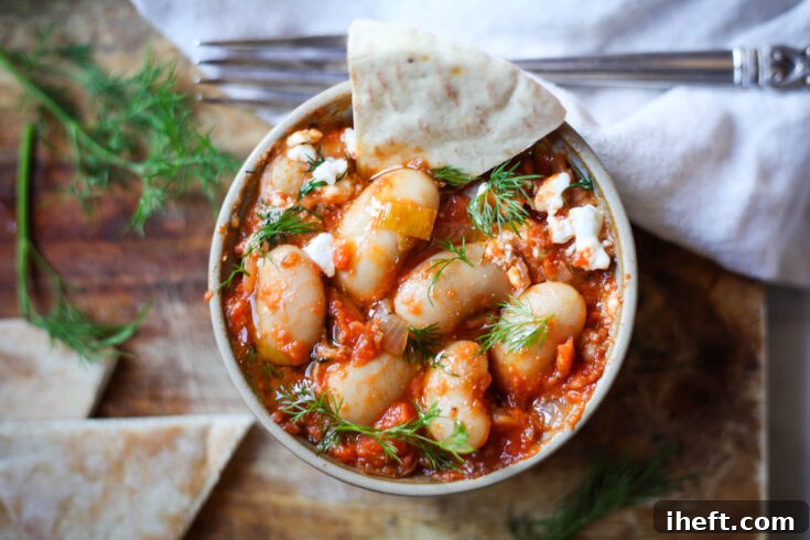 An image highlighting Greek Giant Baked Beans, Gigantes Plaki, with a text overlay for Pinterest, encouraging users to discover this Mediterranean vegetarian recipe.