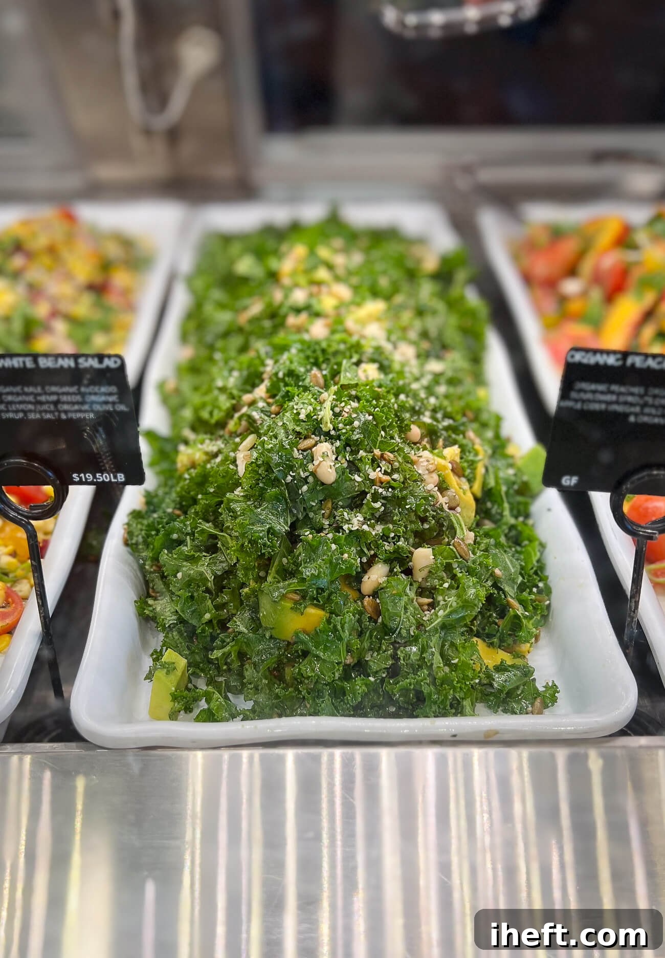 A large rectangular platter of Kale and White Bean Salad in an Erewhon deli case. 