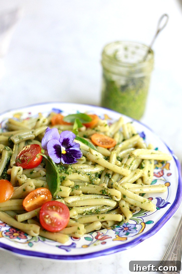 A bowl of homemade pesto pasta with tomatoes. 
