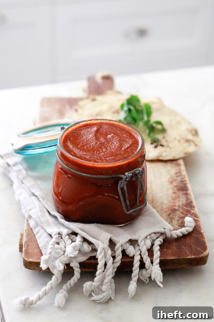 A glass jar of homemade enchilada sauce, ready for use.