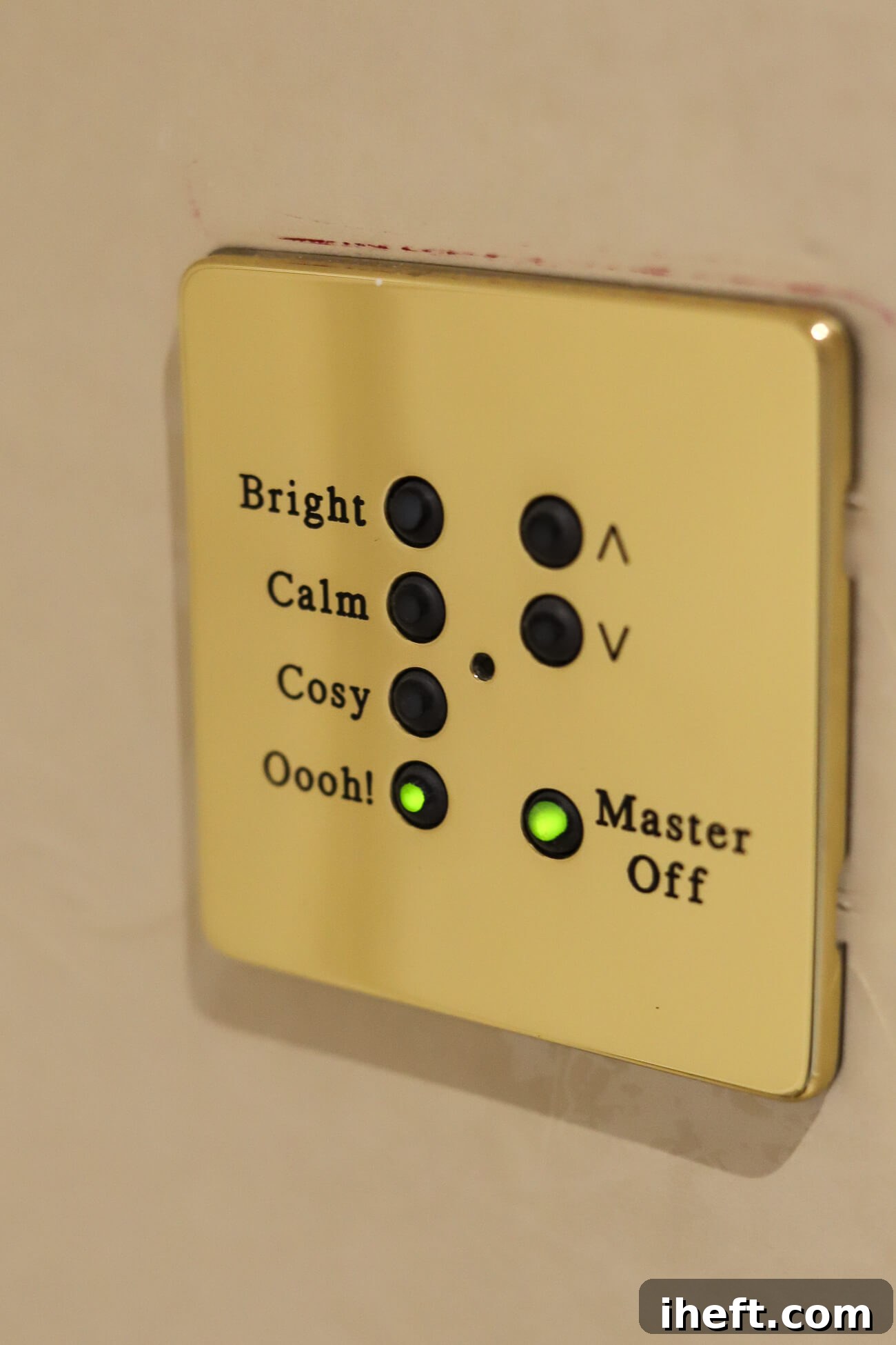 A gold light switch with buttons for "bright, calm, cozy, and Oooh!"