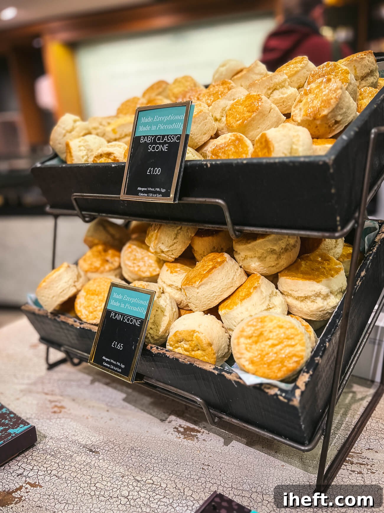 Two tiers of classic plain English scones displayed at Fortnum & Mason in London. The price tags below read "Baby Classic Scone £1.00" and "Plain Scone £1.65" at the bottom tier, showcasing their traditional simplicity.