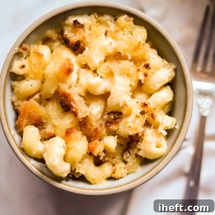 A ceramic bowl filled with Ina Garten's recipe for baked mac and cheese with breadcrumbs.