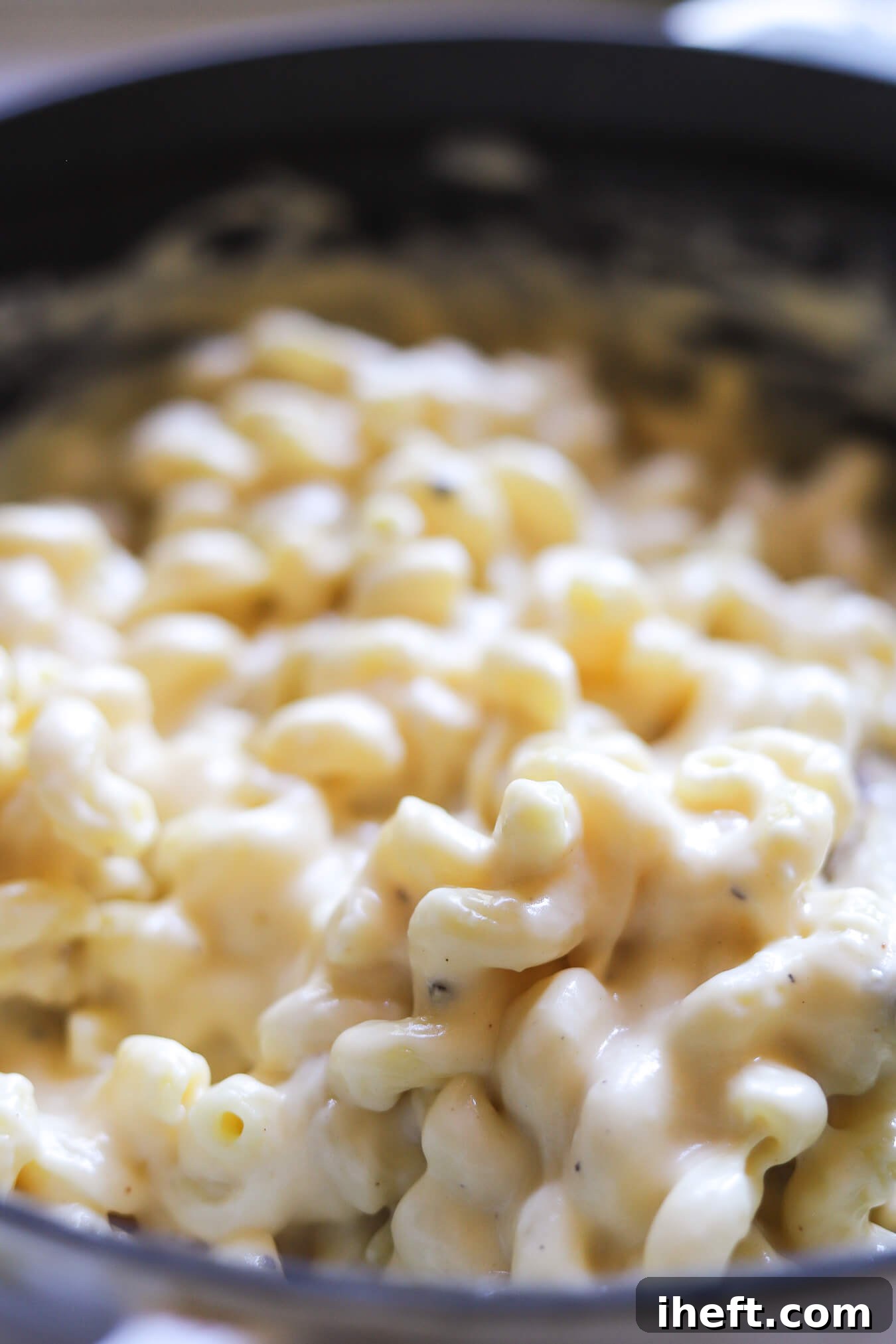 Cooked pasta is coated in mac and cheese sauce.