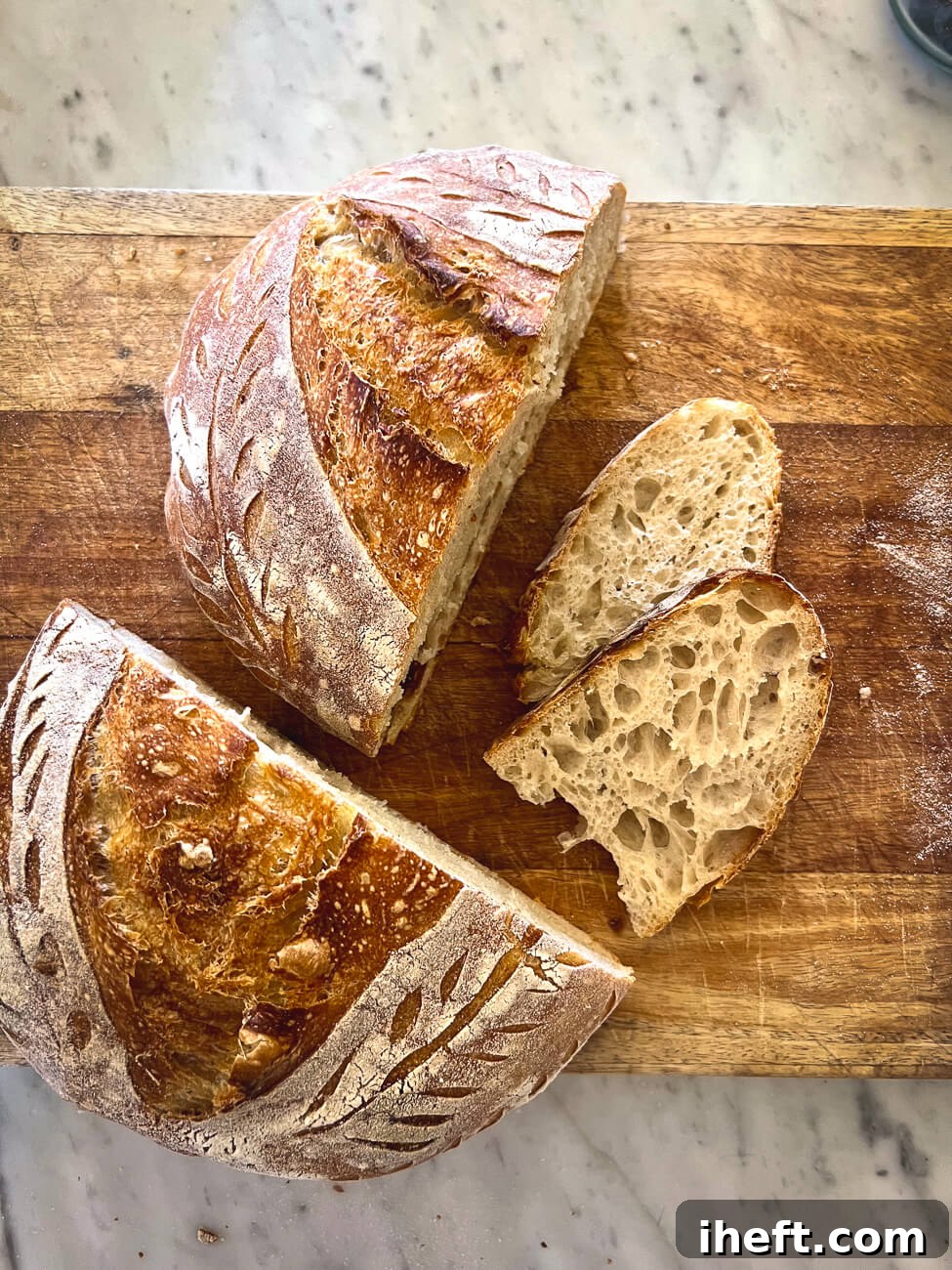 Freshly baked homemade sourdough boule in a Dutch oven with parchment paper.