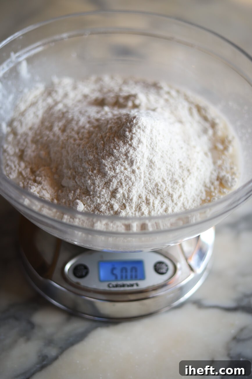 Sourdough ingredients being mixed in a bowl on a kitchen scale.