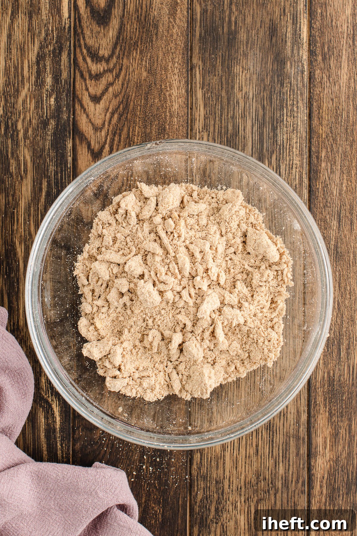 A medium glass bowl filled with a homemade crumbly streusel topping.
