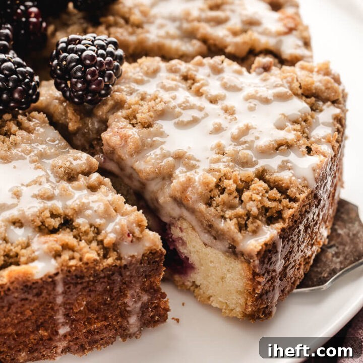 Blackberry coffee cake with streusel topping, glaze, and blackberries.