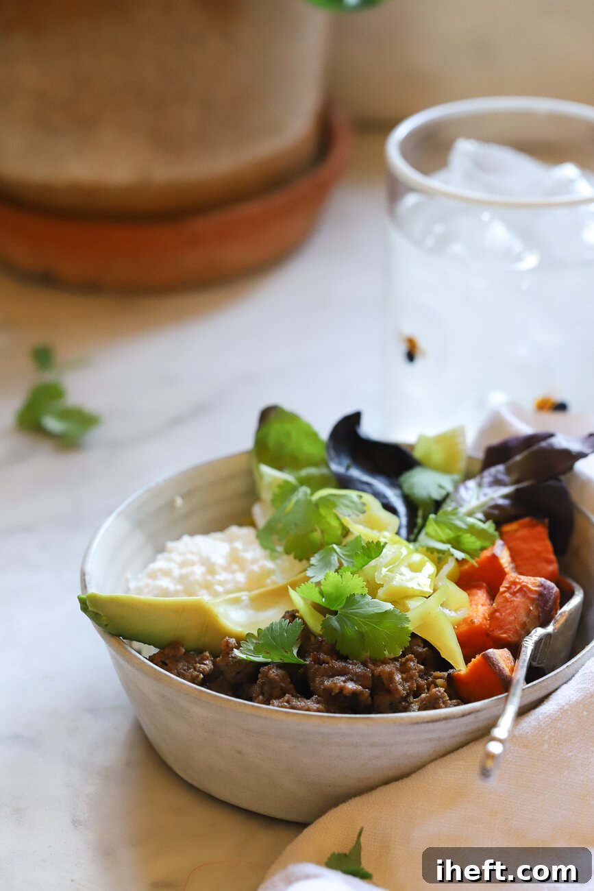 A high protein lunch bowl made with ground beef, sweet potato, avocado, greens, and cilantro. 