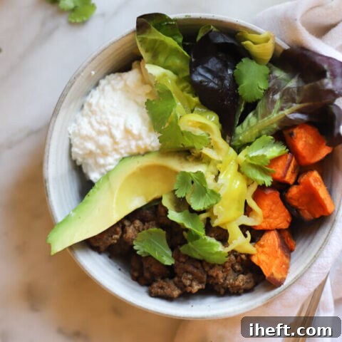 A delicious and high protein bowl made with ground beef, roasted sweet potato, greens, cilantro, cottage cheese, and avocado.