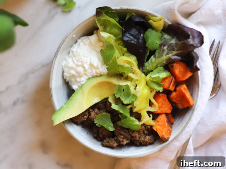 A delicious and high protein bowl made with ground beef, roasted sweet potato, greens, cilantro, cottage cheese, and avocado.