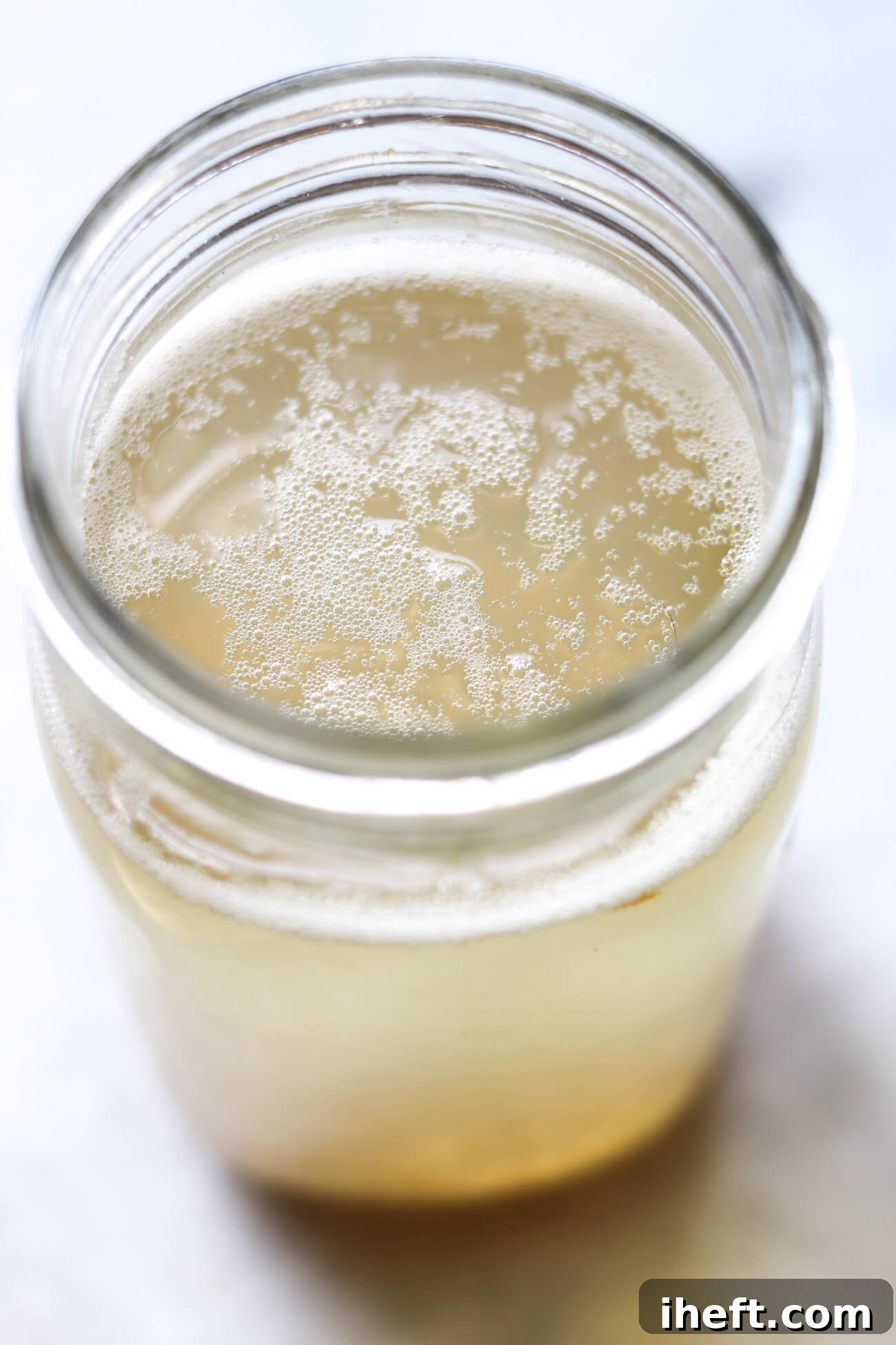 Close-up of a jar filled with water kefir after the first ferment. Small bubbles are seen at the surface.