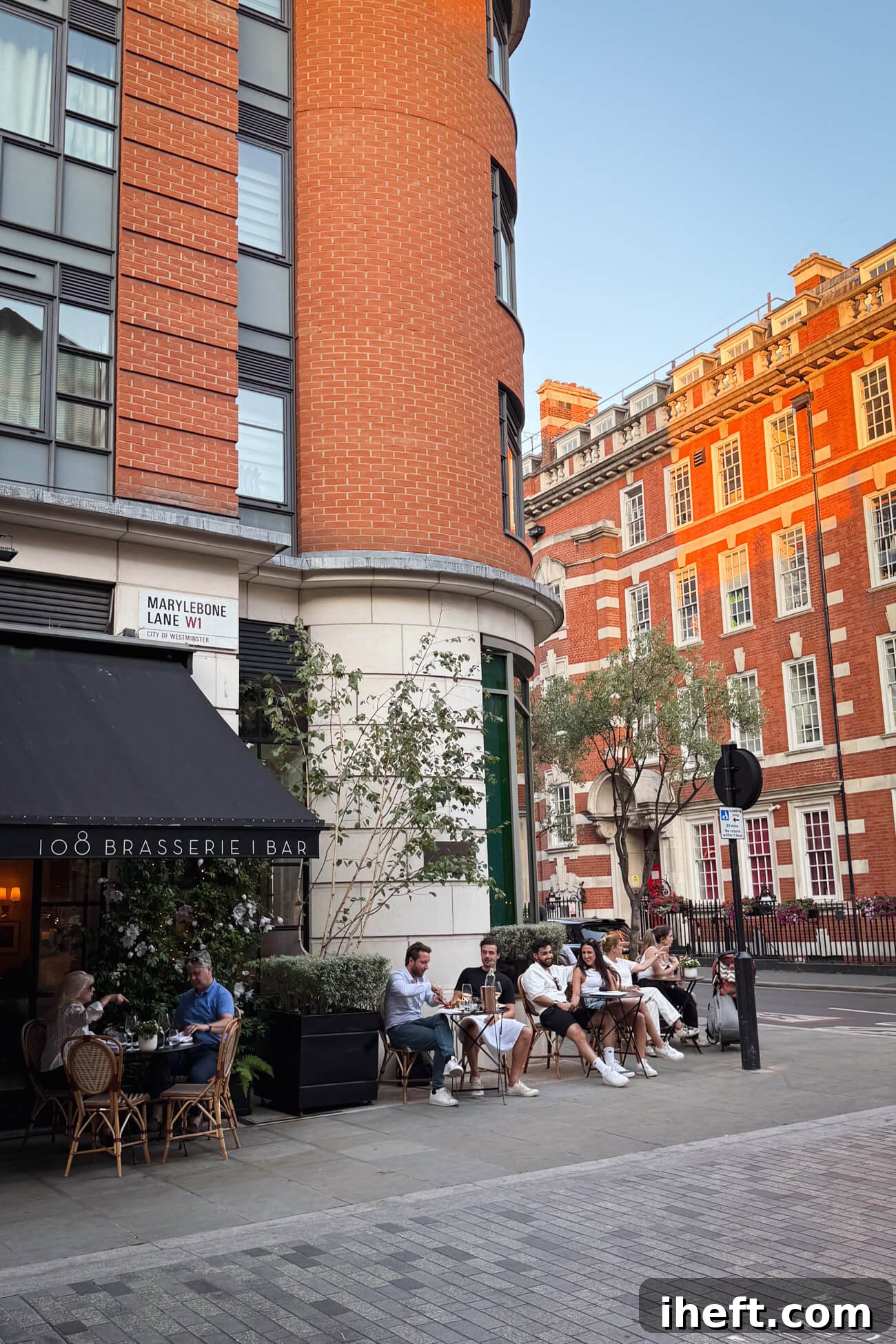 People sit at tables outside 108 Brasserie and Bar at the Marylebone Hotel on Marylebone Lane in London. 
