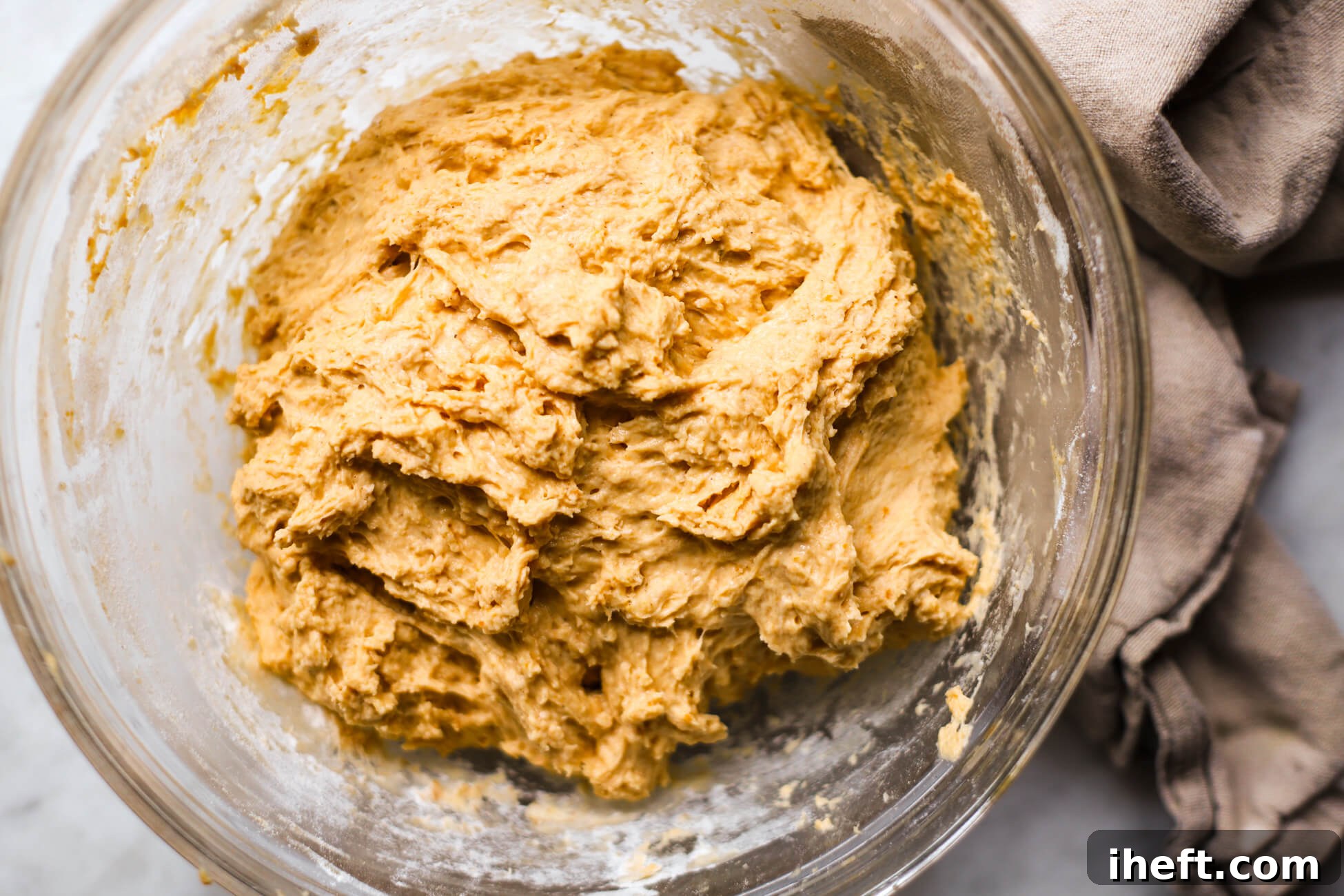 Pumpkin sourdough bread dough just mixed together in a glass bowl.