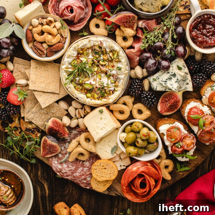 An overhead photo of a big Christmas charcuterie grazing board loaded with cheeses, meats, fruit, and festive touches. This is the ultimate Christmas party food.