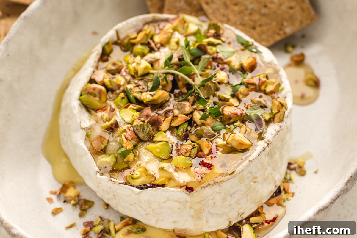 A whole round of Brie cheese baked until gooey and topped with hot honey and pistachios.