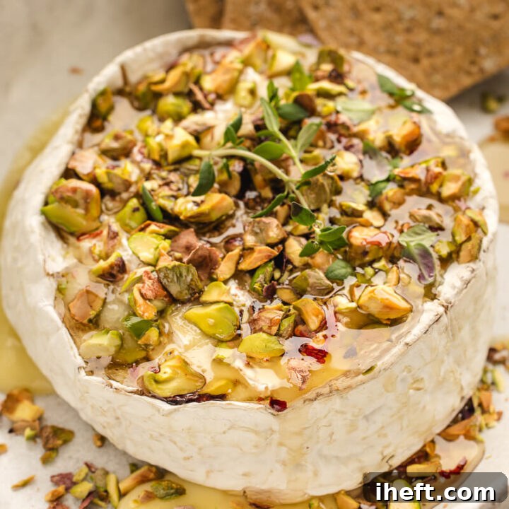 A whole round of Brie cheese baked until gooey and topped with hot honey and pistachios.